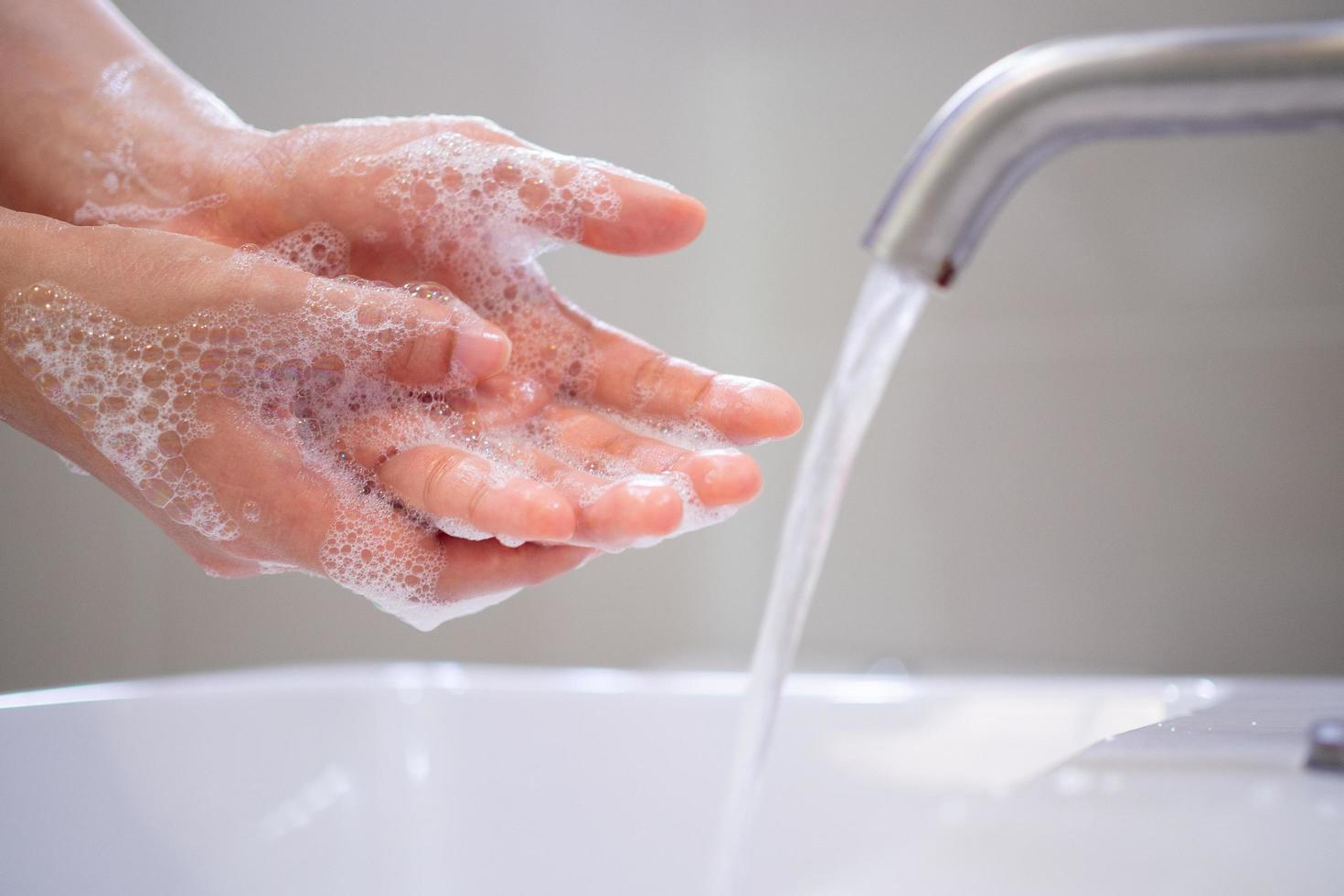 lavare il tuo mani con sapone, impedire virus e batteri nel il rubinetto con in esecuzione acqua. bene igiene prima mangiare o maneggio pubblico elementi foto