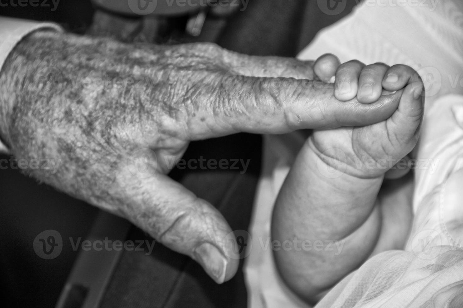 vecchio pensionato uomo mani Tenere neonato infantile uno foto