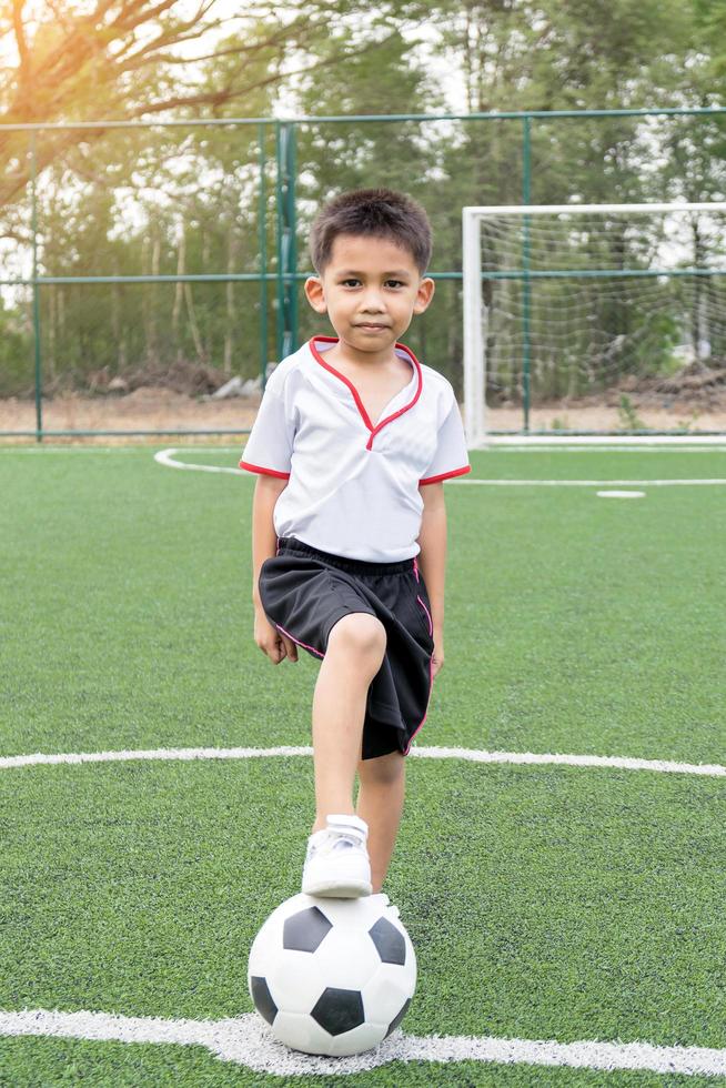 piccolo ragazzo che gioca a calcio foto