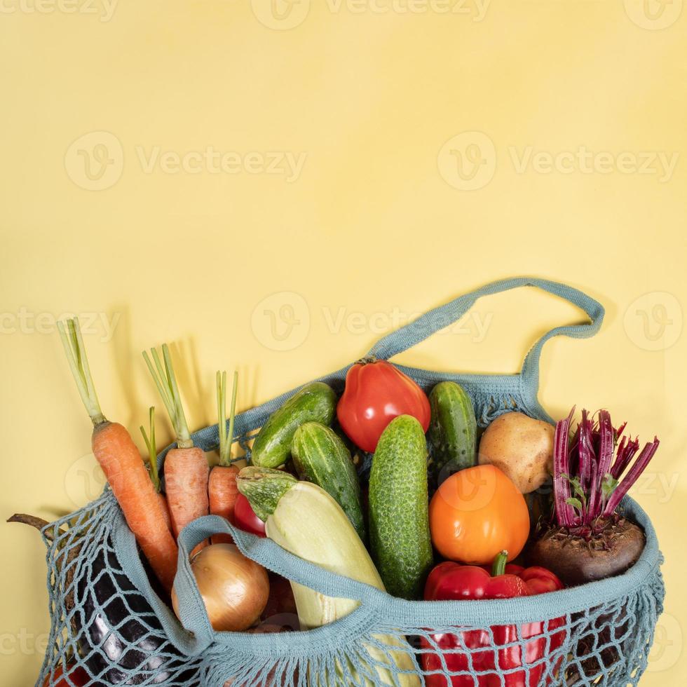 avvicinamento corda Borsa pieno di fresco azienda agricola verdure su giallo sfondo con copia spazio. foto