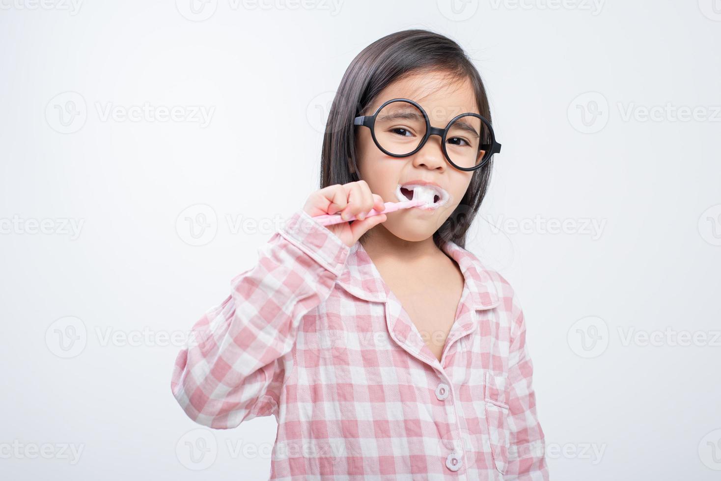 poco ragazza Asia spazzolatura denti felicemente bianca sfondo foto