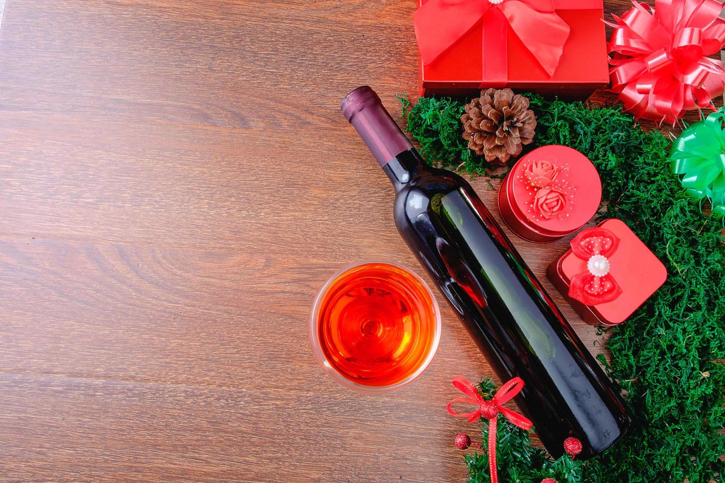 bicchiere di vino e bottiglia con confezione regalo di Natale foto