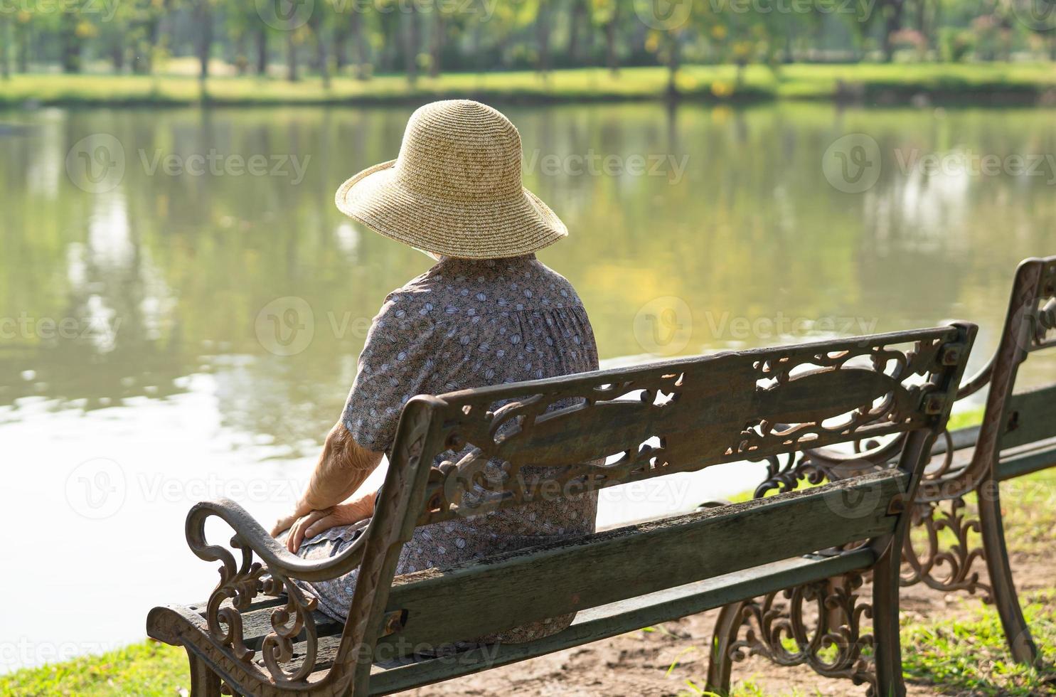 donna anziana asiatica depressa e triste seduta sulla panchina nel parco autunnale. foto