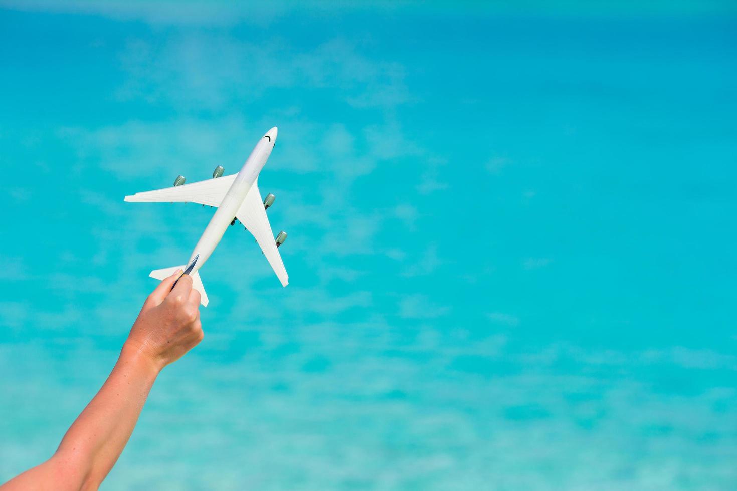 aeroplano giocattolo contro un mare turchese foto