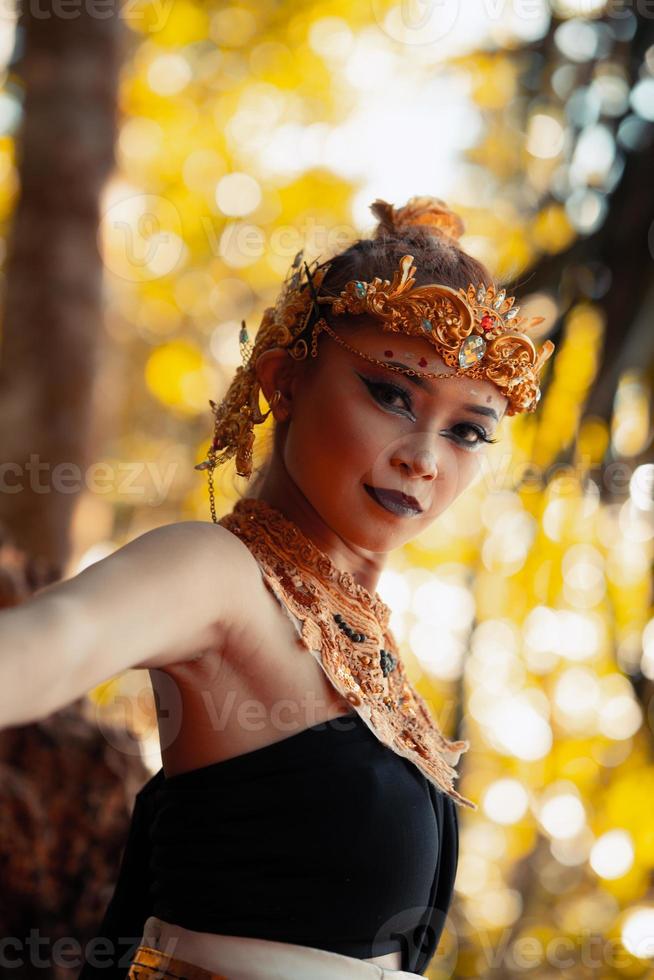 ritratto di asiatico donna indossare un' oro corona e oro collana con sua bellissima trucco nel nero vestito foto