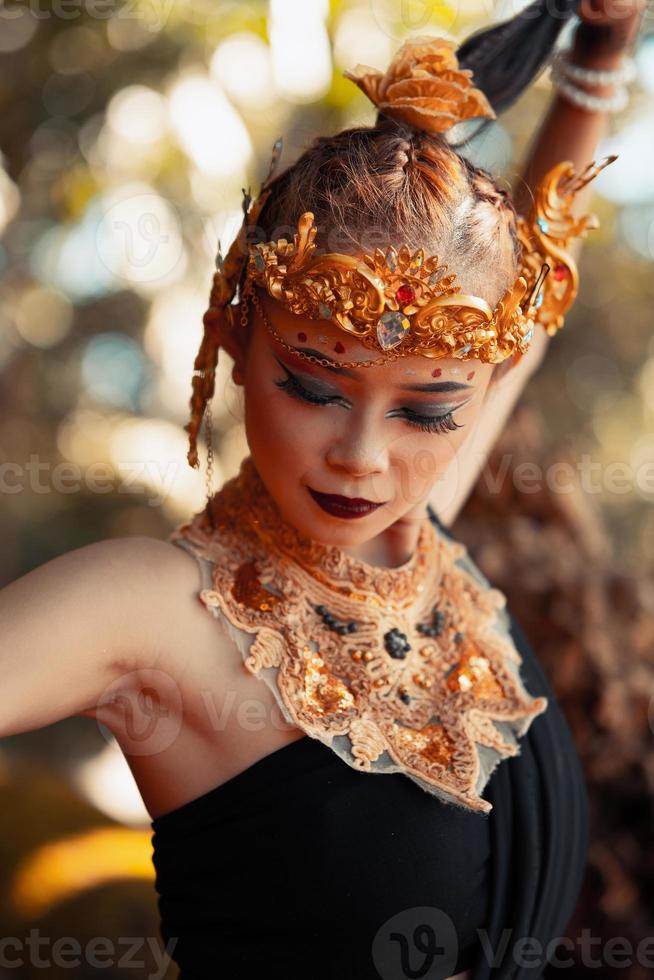 ritratto di asiatico donna indossare un' oro corona e oro collana con sua bellissima trucco nel nero vestito foto
