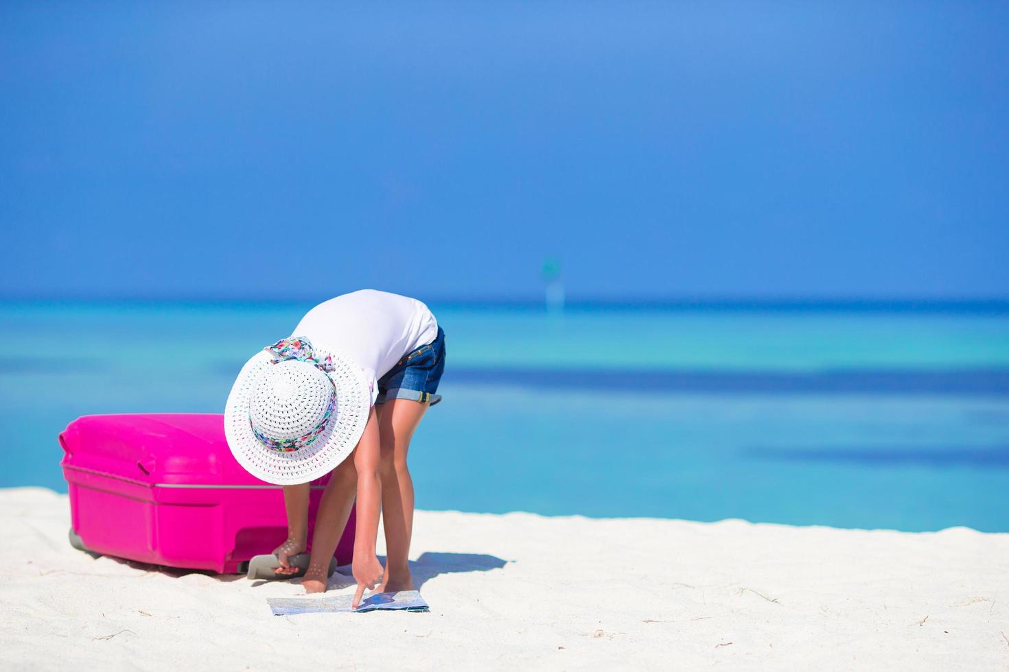 ragazza guardando una mappa su una spiaggia foto