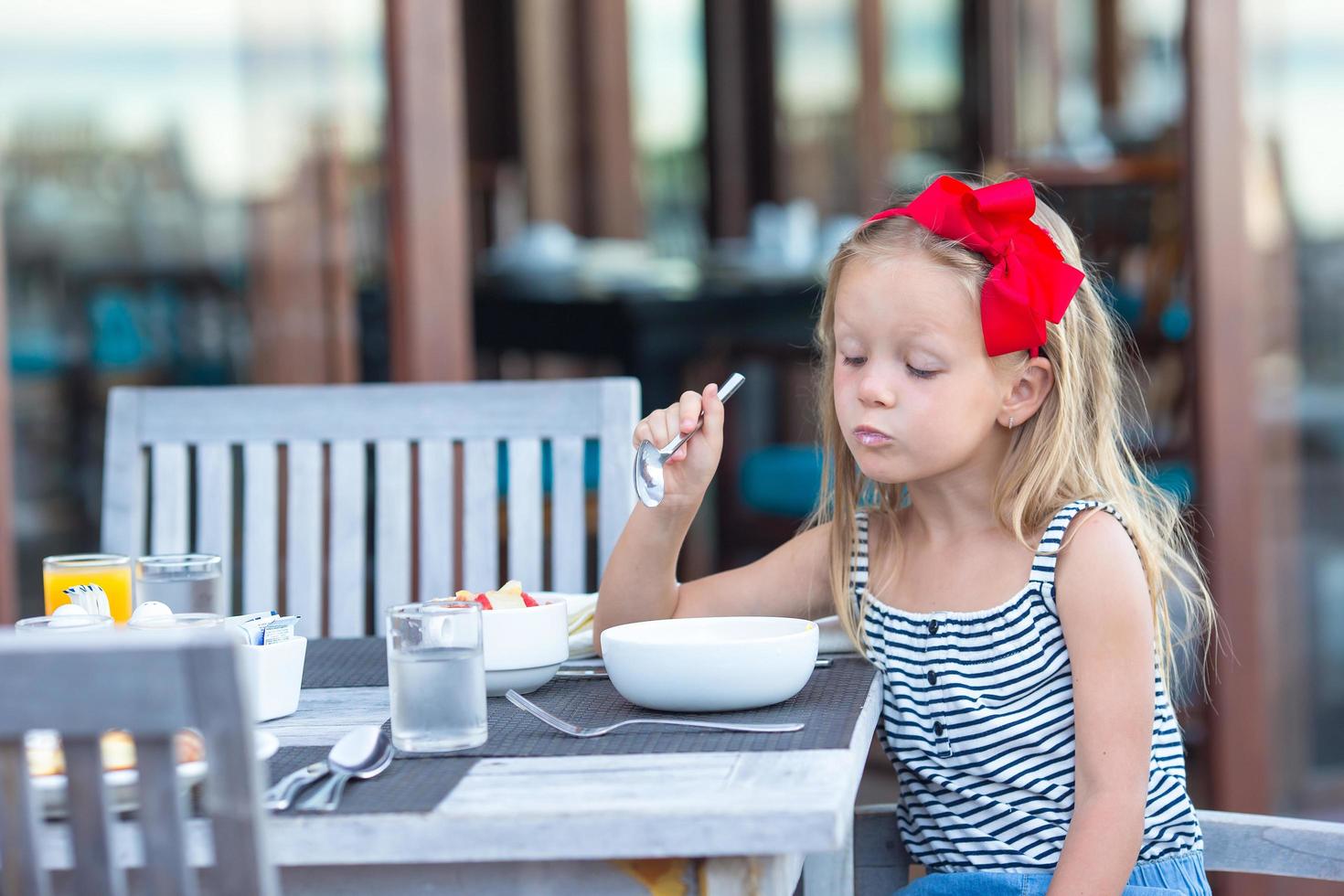 ragazza che mangia porridge in un caffè all'aperto foto