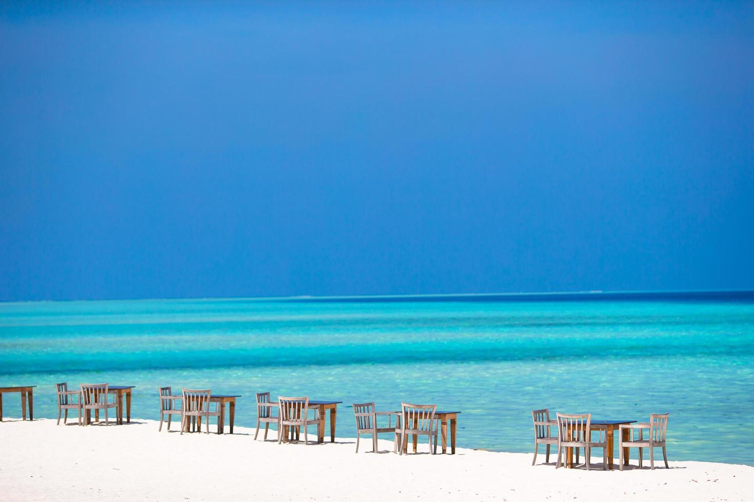 maldive, asia meridionale, 2020 - tavolo e sedie da esterno vuoti in riva all'oceano foto