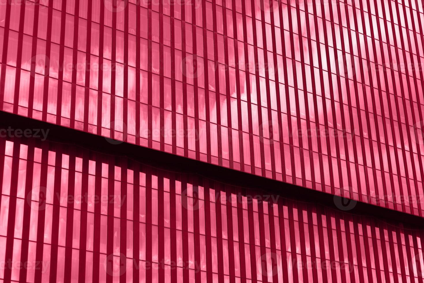 prospettiva Visualizza ufficio edificio facciata, cielo riflessi nel finestre. moderno grattacielo tonica in Viva magenta colore. ispirato di pantone colore di il anno 2023. orizzontale foto con posto per testo.