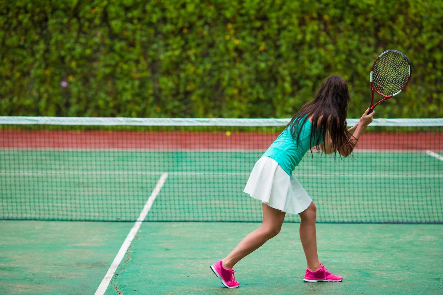 donna che gioca a tennis in un campo da tennis foto