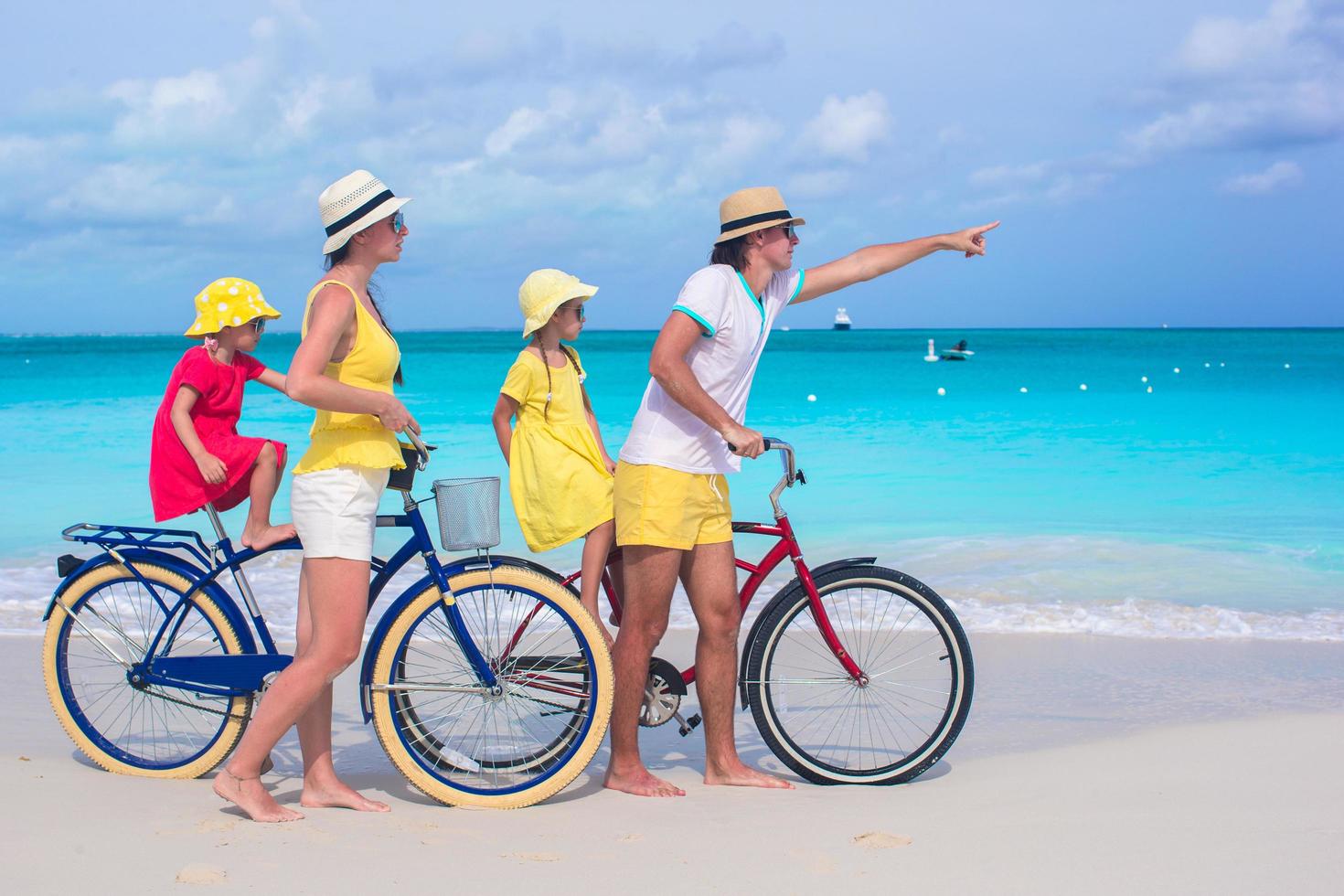 famiglia in sella a biciclette su una spiaggia tropicale foto