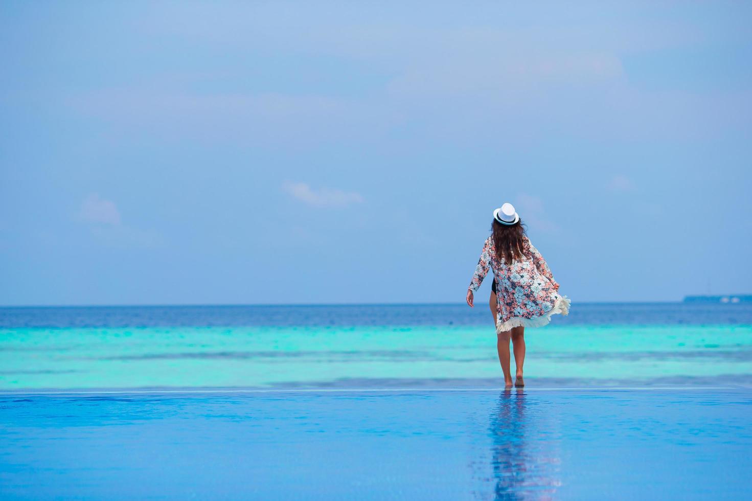 donna in piedi sul bordo della piscina a sfioro foto