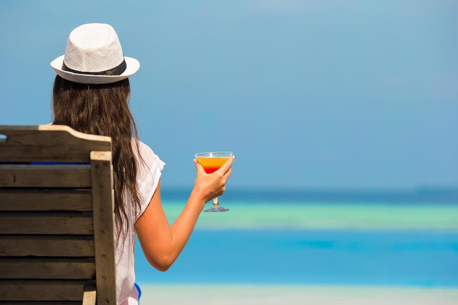 donna con bicchiere da cocktail vicino alla piscina foto