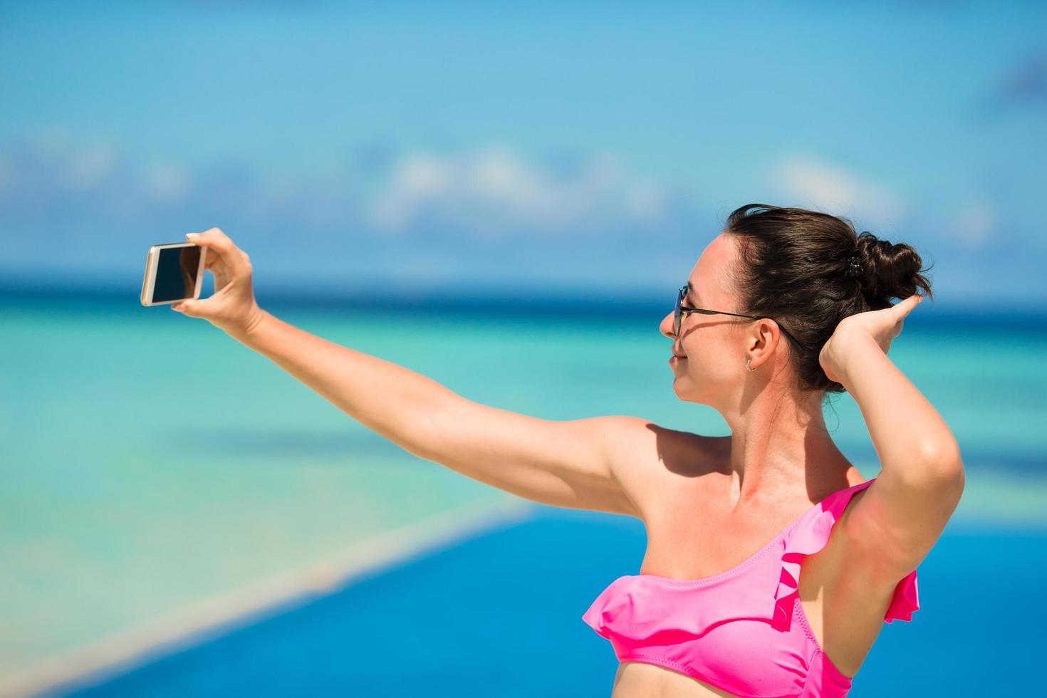 donna che cattura un selfie in una piscina foto