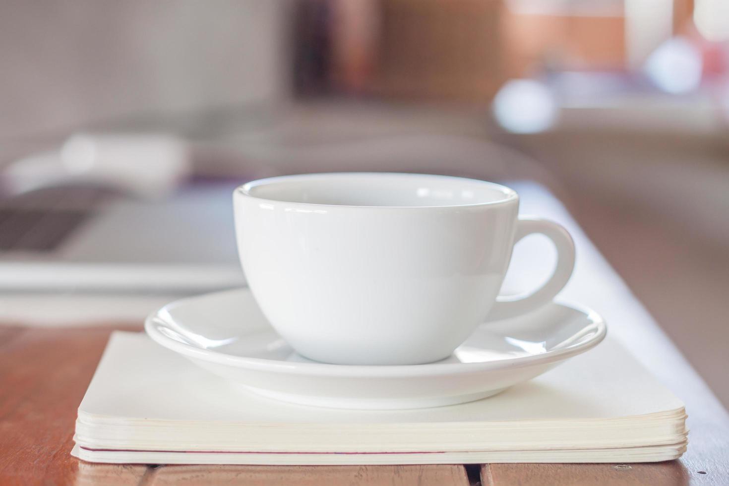 tazza di caffè bianco sulla stazione di lavoro foto