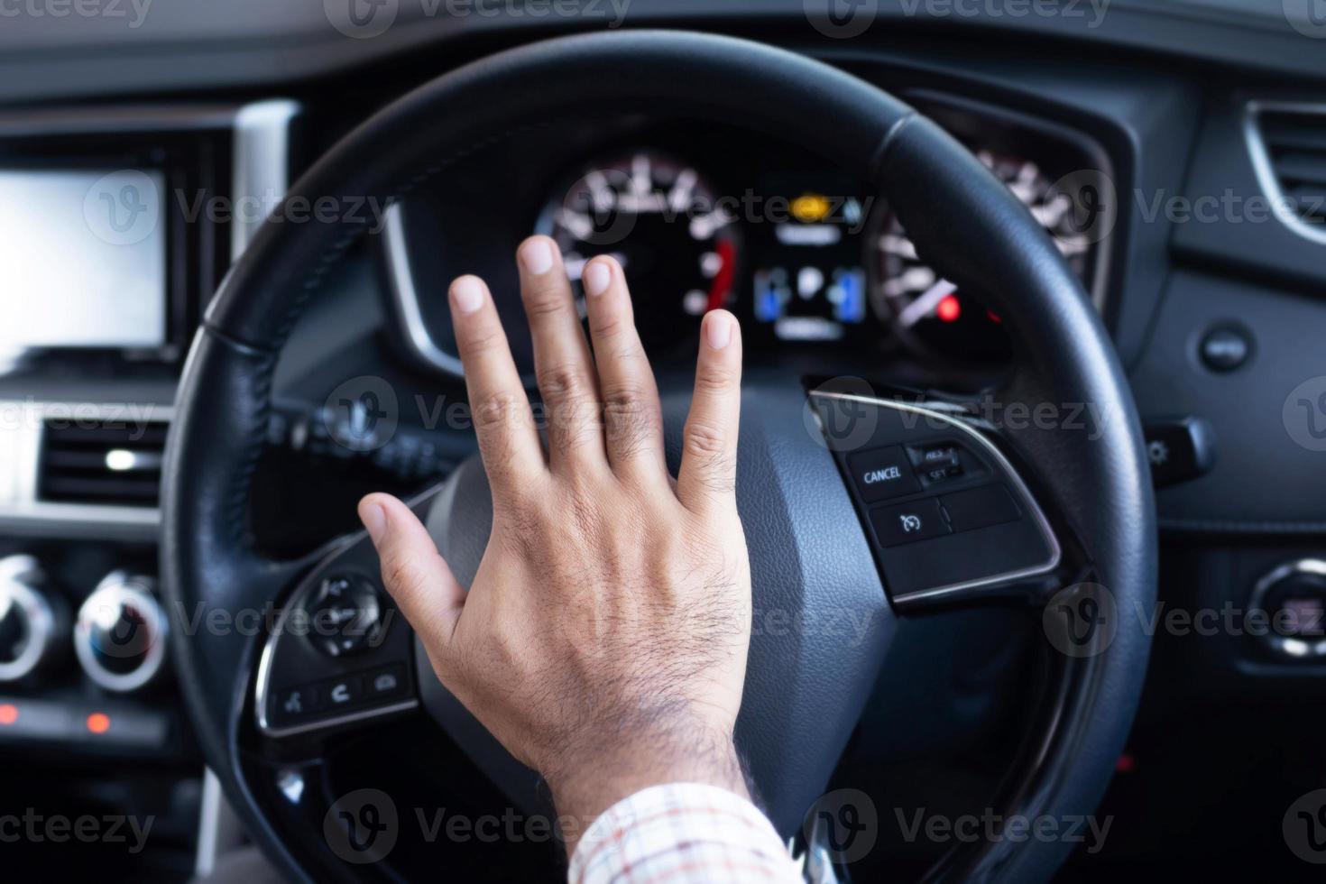 uomo spingendo corno mentre guida seduta di un' timone ruota stampa macchina, clacson suono per avvisare altro persone foto