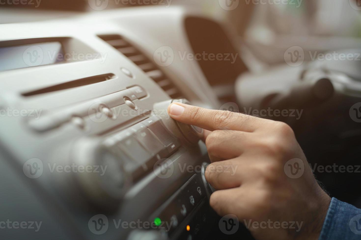 vicino su mano Aperto auto Radio ascoltando. auto autista mutevole svolta pulsante Radio stazioni su il suo veicolo multimedia sistema. moderno toccare schermo Audio stereo sistema. mezzi di trasporto e veicolo concetto foto