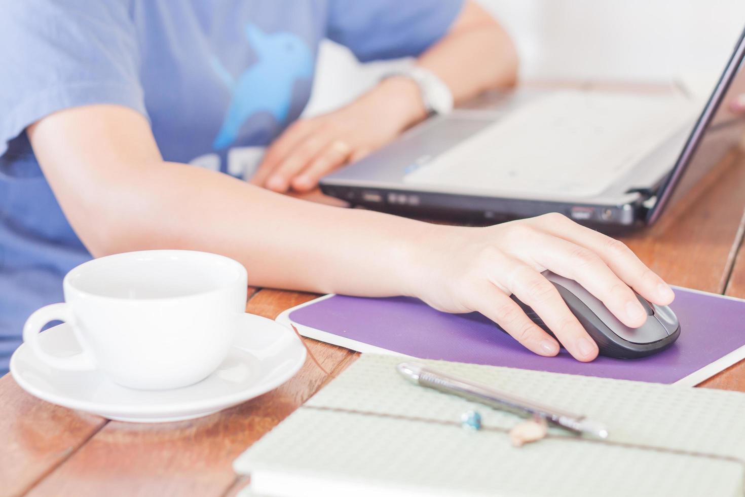 donna che lavora su un computer portatile in una caffetteria foto