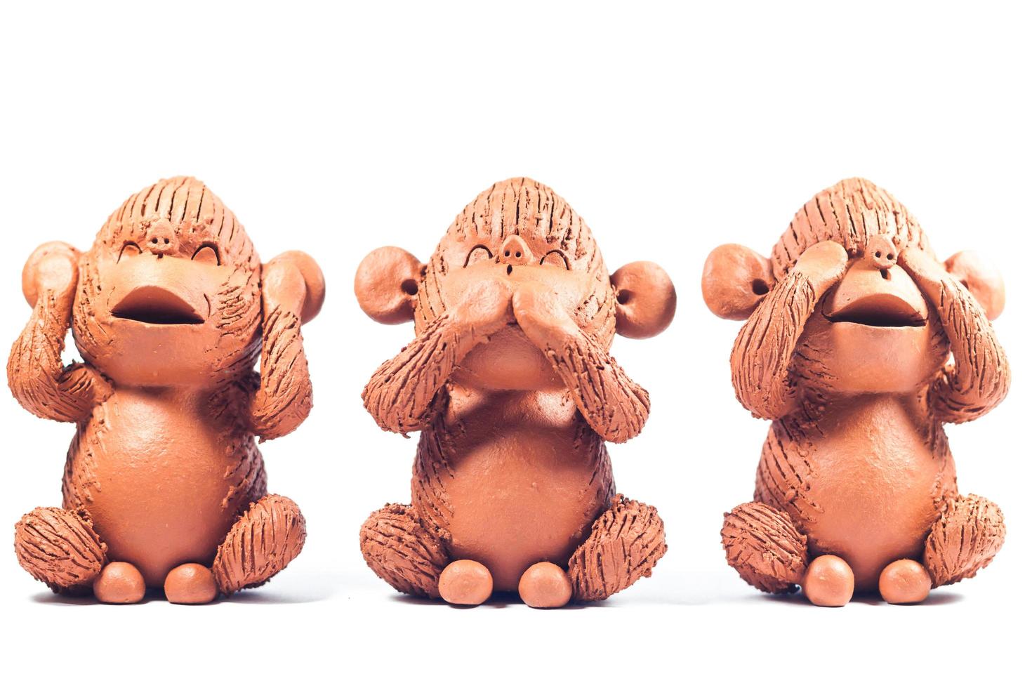 tre scimmie di argilla su uno sfondo bianco foto