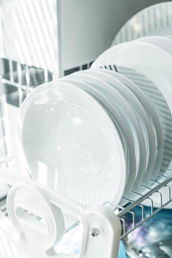 piatti bianchi puliti su uno scolapiatti foto
