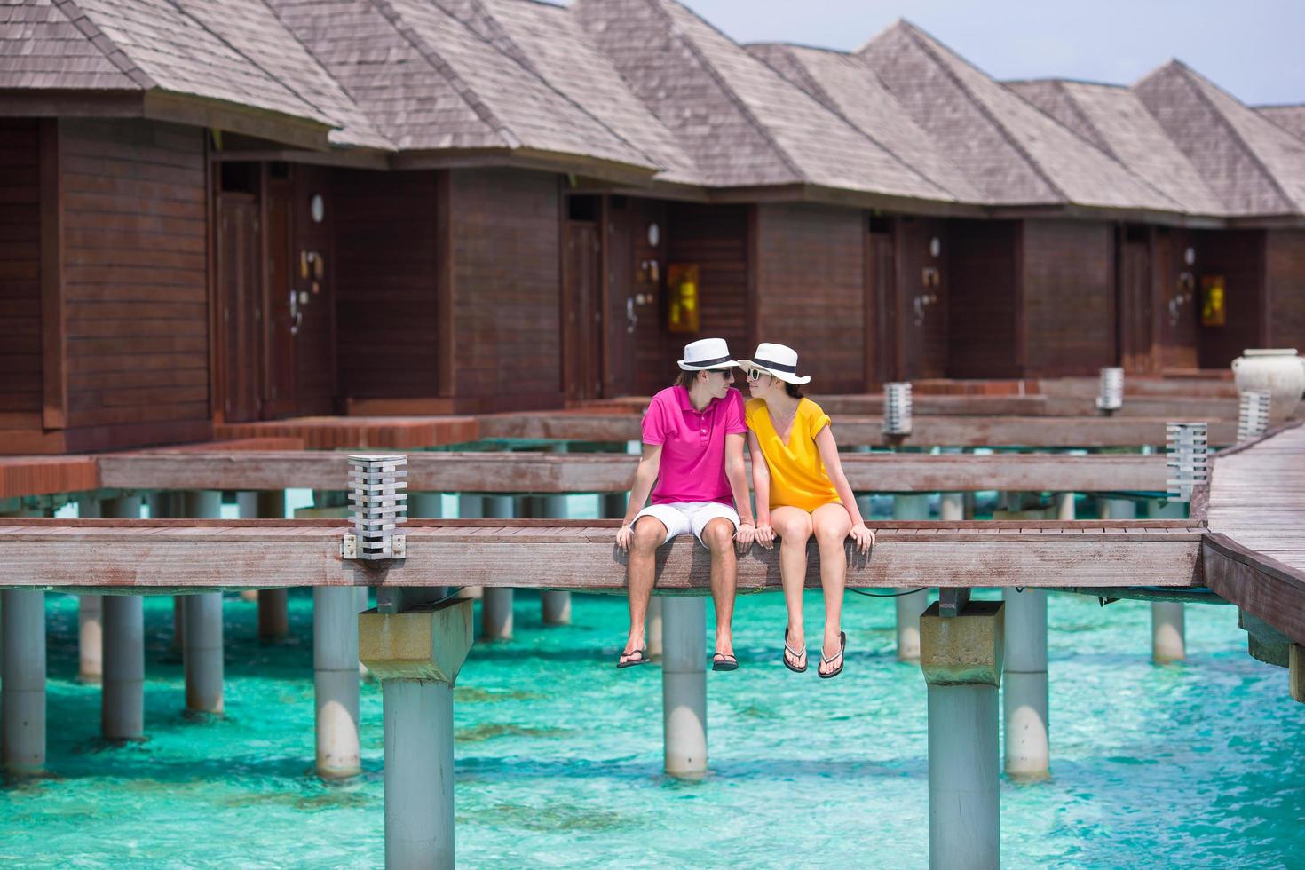 maldive, asia meridionale, 2020 - giovane coppia su un molo di una spiaggia tropicale vicino a un bungalow sull'acqua foto