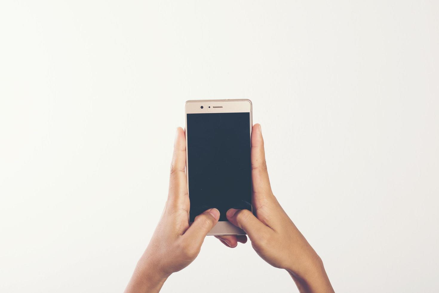 primo piano della mano della donna sul telefono cellulare isolato su priorità bassa bianca foto