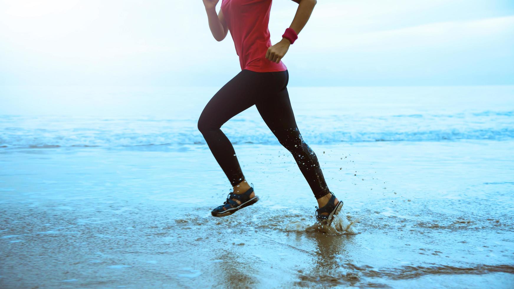 donna jogging allenarsi su il spiaggia nel il mattina. rilassare con il mare camminare. saltare su e divertimento su allenamento. foto