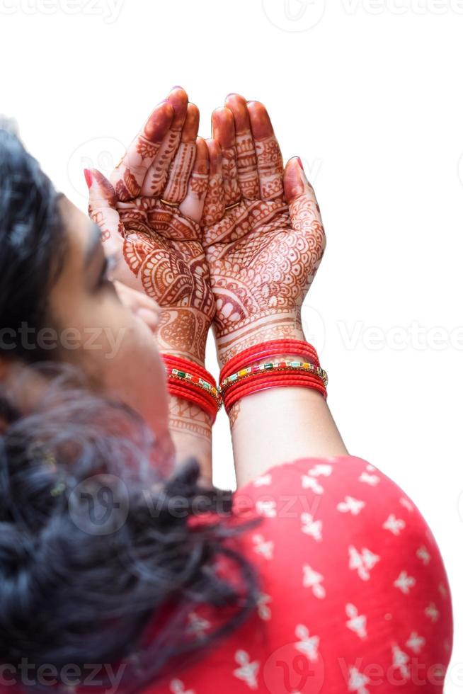 bellissimo donna vestito su come indiano tradizione con alcanna mehndi design su sua tutti e due mani per celebrare grande Festival di karwa chauth con pianura bianca sfondo foto