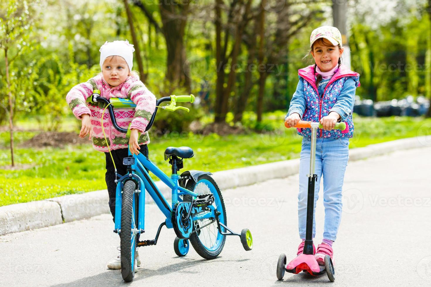 interrazziale gruppo di bambini con bicicletta e scooter sorridente foto