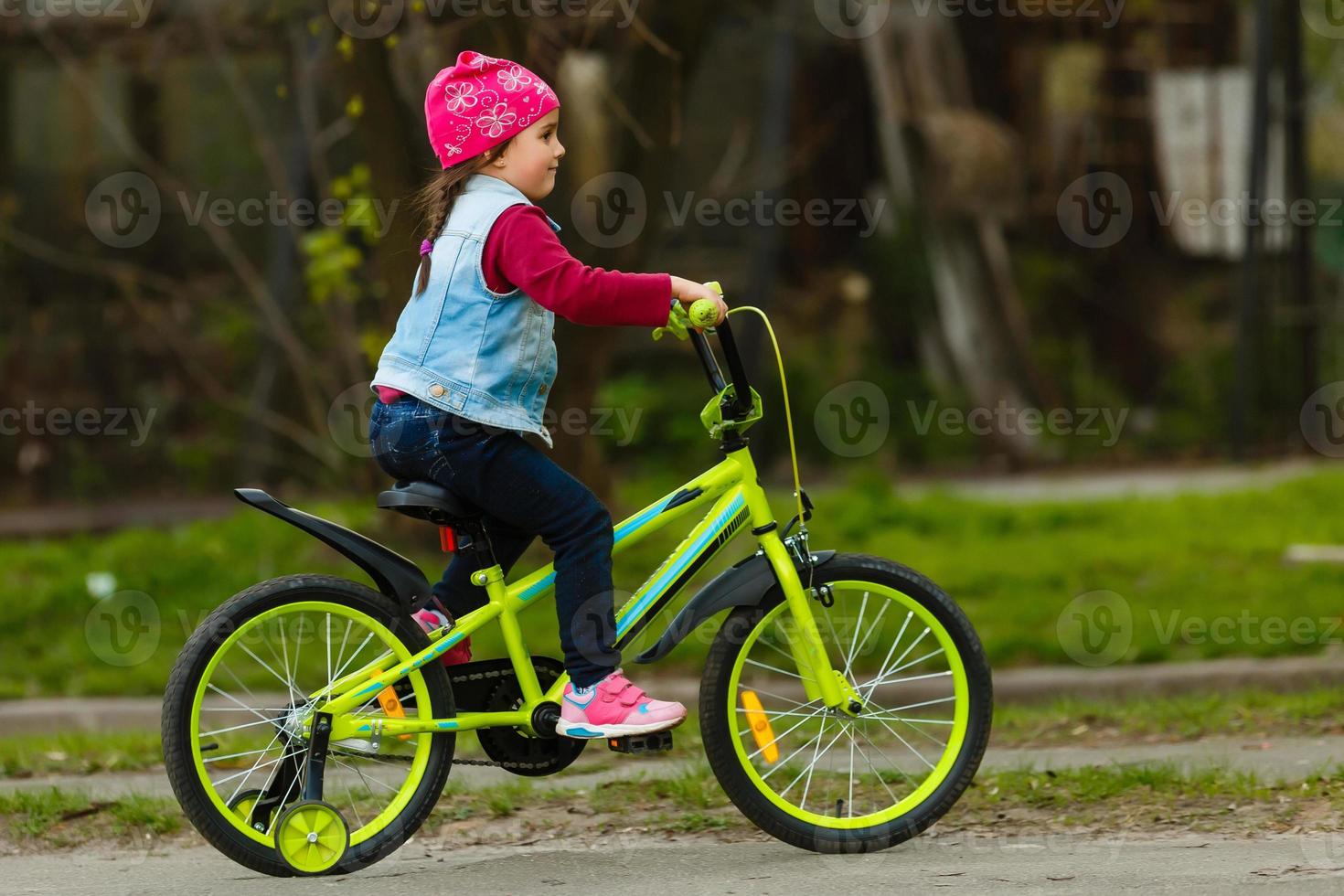 poco ragazza con sua bicicletta foto