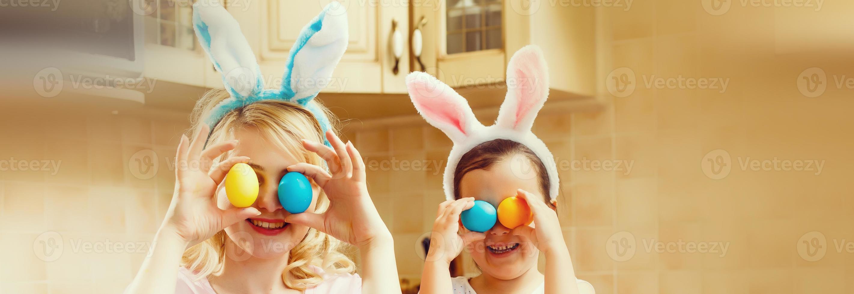 contento Pasqua un' madre e sua figlia pittura Pasqua uova. contento famiglia preparazione per Pasqua. carino poco bambino ragazza indossare coniglietto orecchie su Pasqua giorno. foto