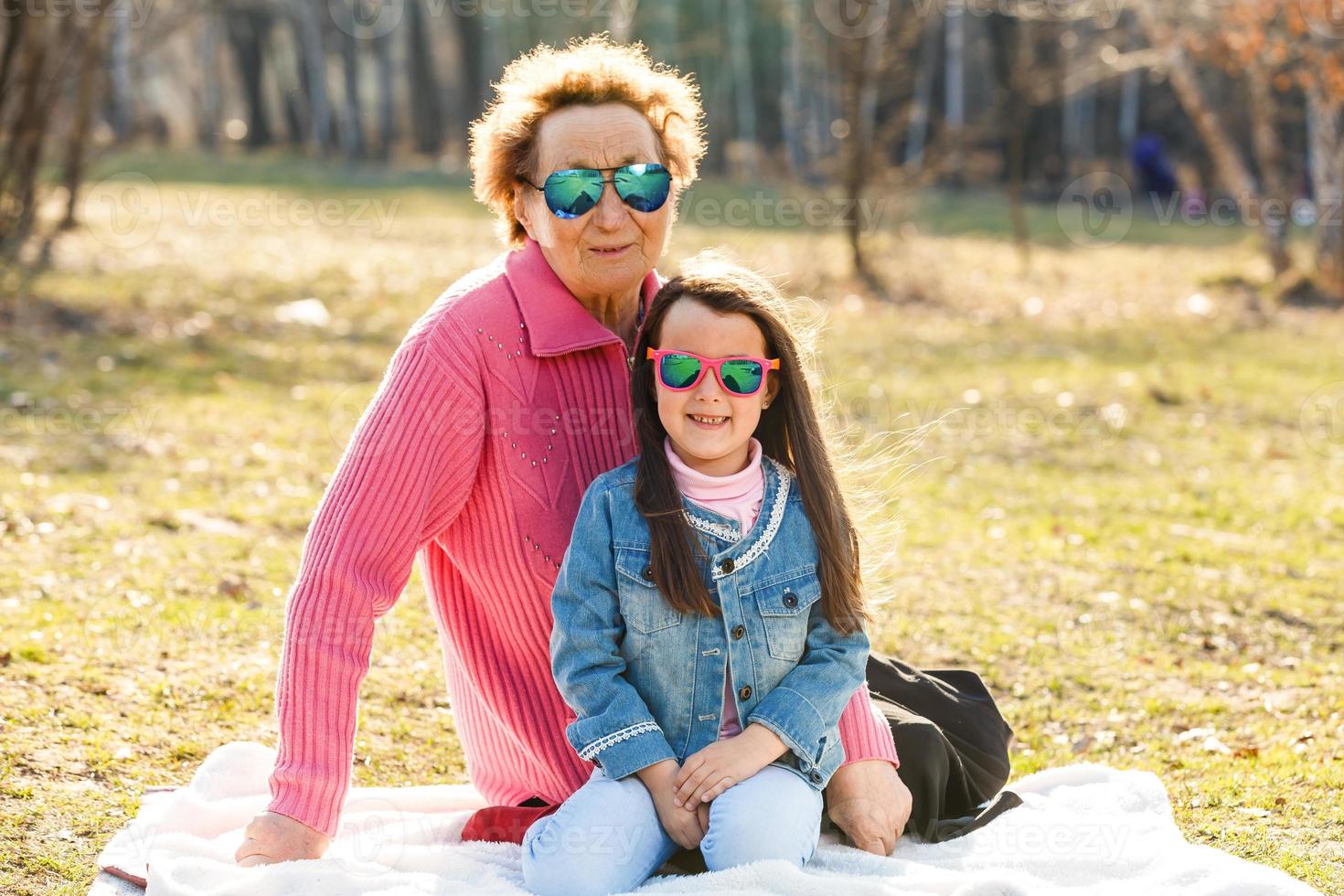 poco ragazza e sua nonna nel occhiali da sole all'aperto foto