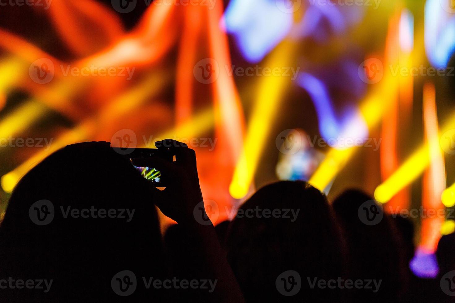 vicino su di Fotografare con smartphone durante un' concerto foto