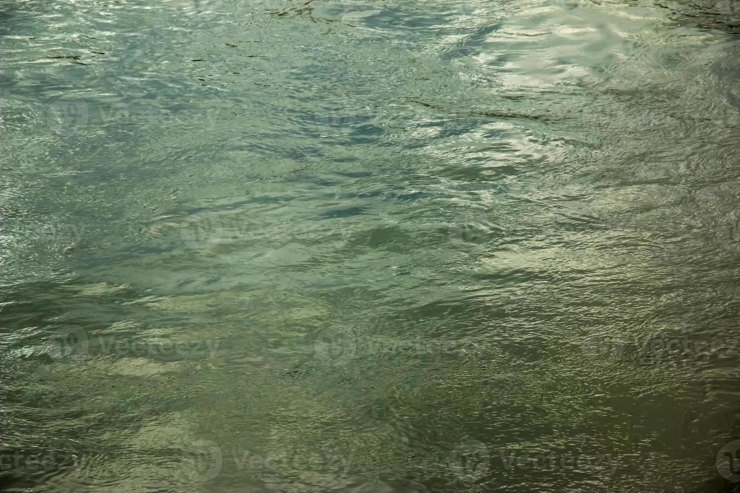 sfondo di il superficie di il Danubio fiume nel un' inverno soleggiato giorno. riflessione di sole bagliore su il acqua superficie con caratteristica increspature. foto