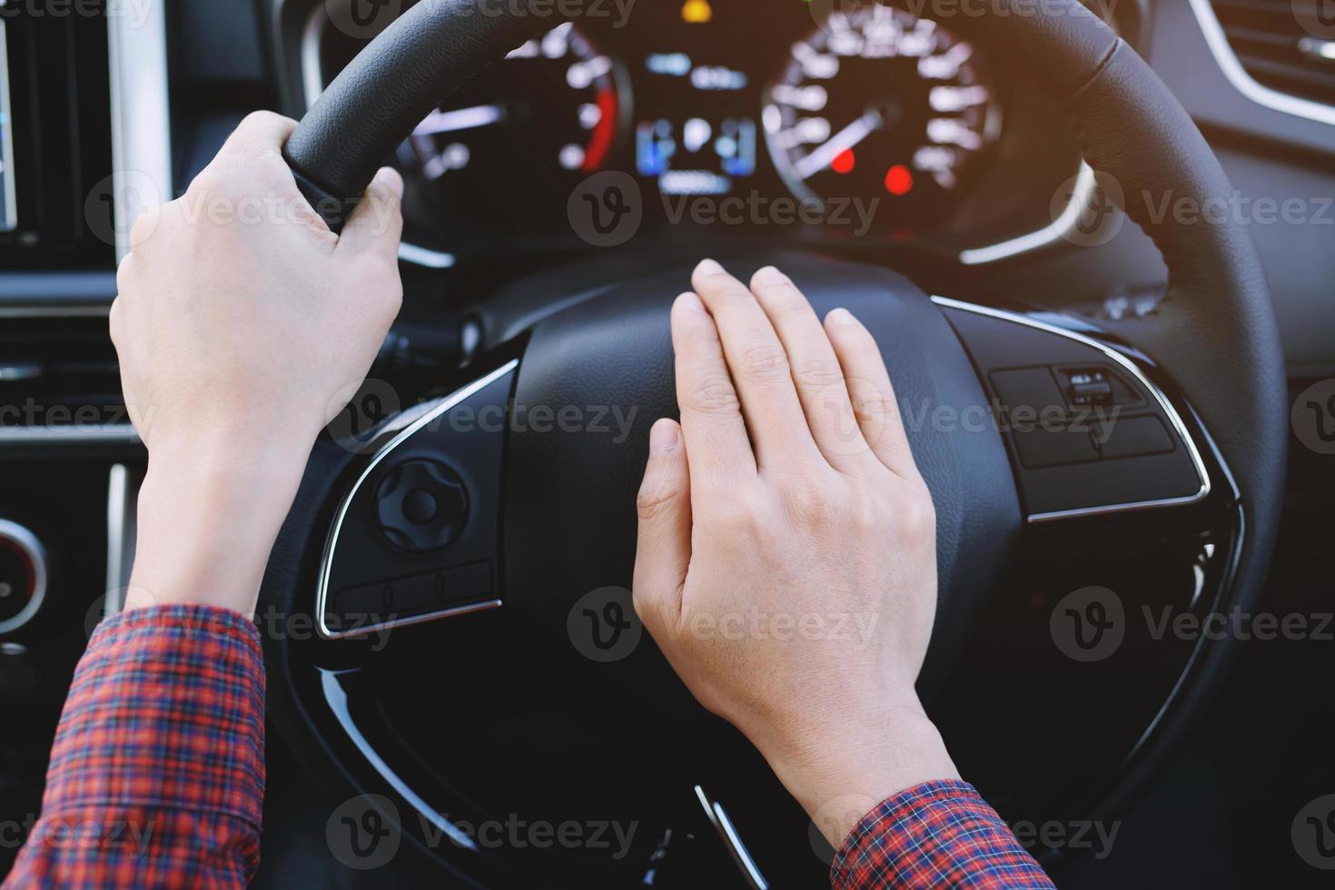 persona che spinge il clacson durante la guida seduto su un'auto della pressa del volante, suonando il clacson per avvisare le altre persone nel concetto di traffico. foto