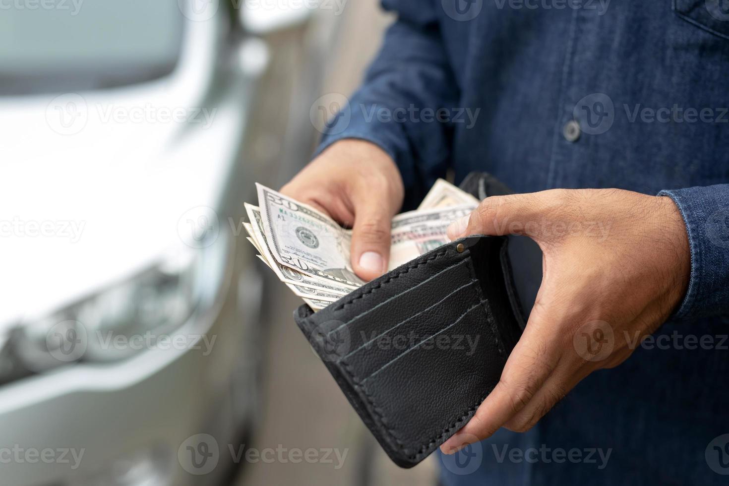 attività commerciale uomo Tenere i soldi nel mano In piedi davanti auto preparare pagare di rate foto