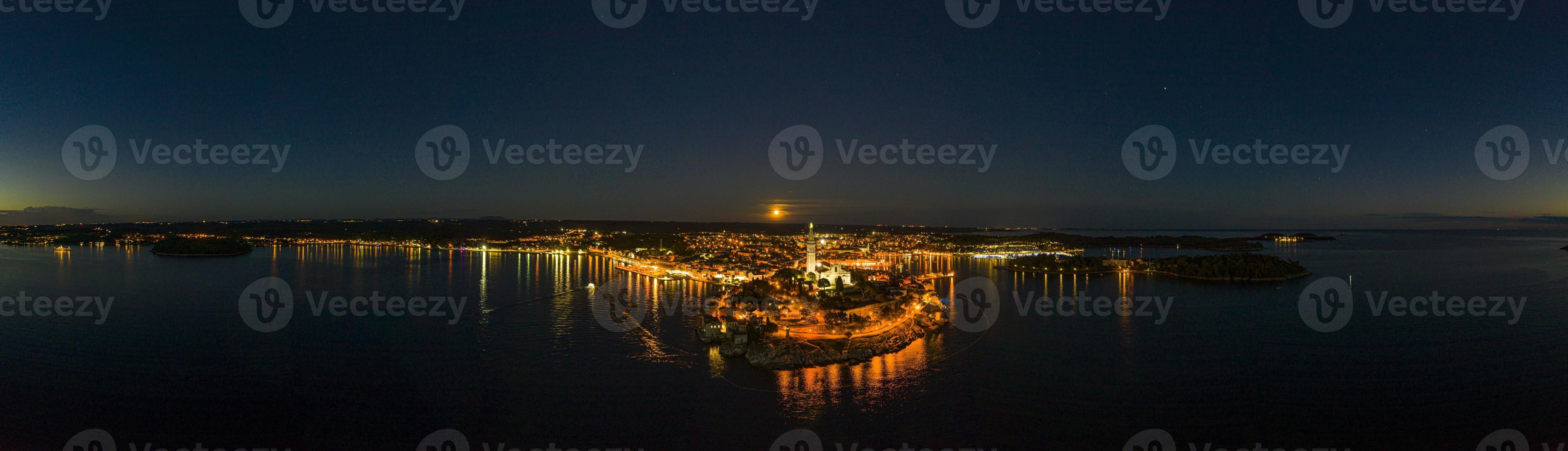 panoramico aereo fuco immagine di il storico città rovigno e porto con pieno Luna nel Croazia durante tramonto foto
