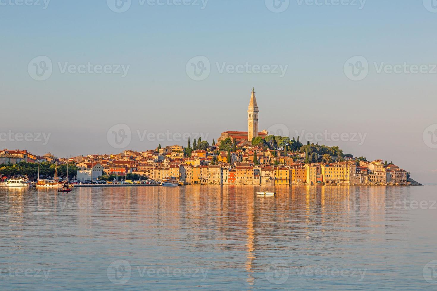 silhouette di il storico città rovigno a mattina tempo con leggero riflessi nel il acqua foto