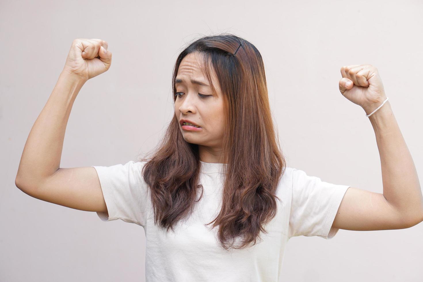 asiatico donne flettere loro muscoli e mostrare loro forza. foto