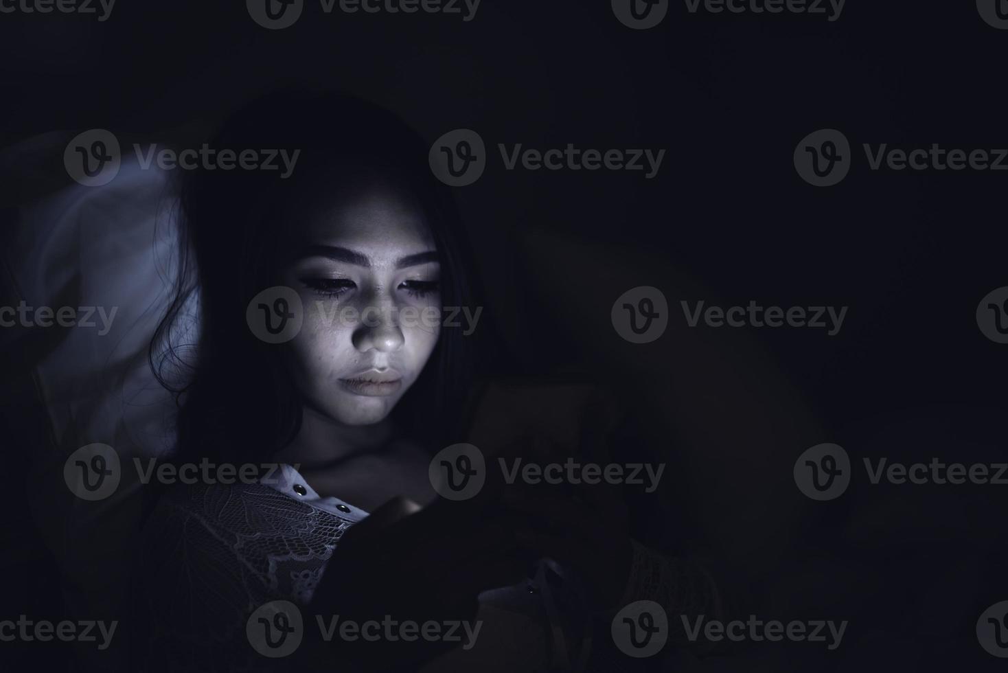 asiatico donna giocare smartphone nel il letto a notte, Tailandia persone foto