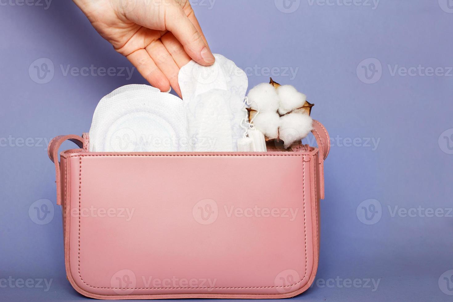 Da donna mano prende su collant rivestimento a partire dal rosa cosmetico Borsa con tamponi e femminile sanitario pastiglie foto