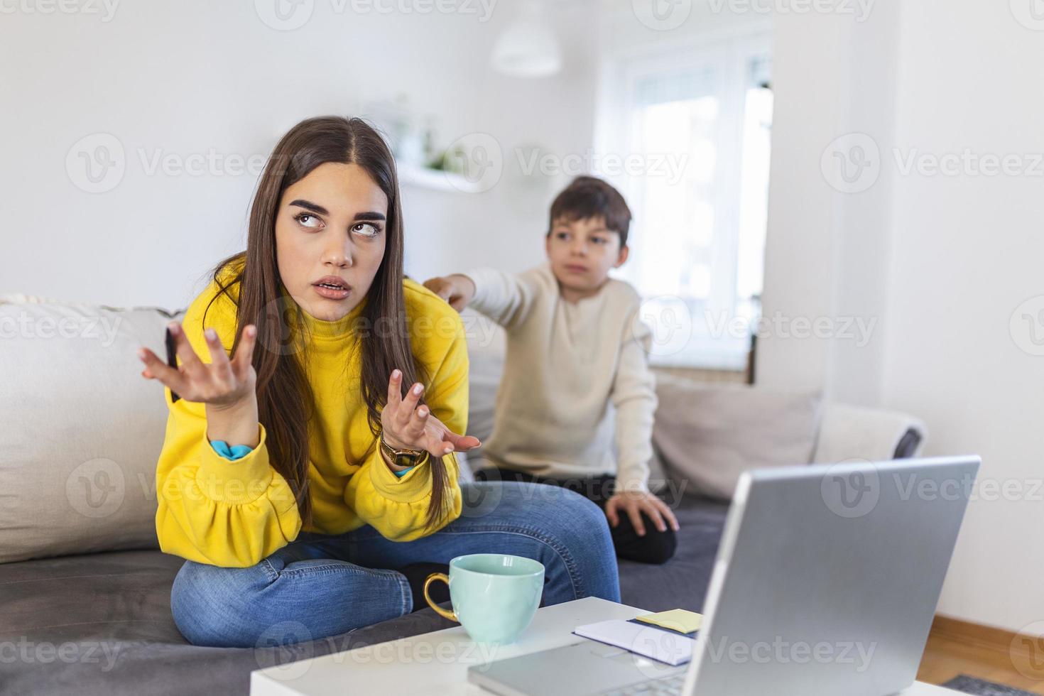 madre Lavorando a partire dal casa con bambini. quarantena e chiuso scuola durante coronavirus scoppio. ragazzo fabbricazione rumore e disturbare donna a opera. homeschooling e libero professionista lavoro. foto