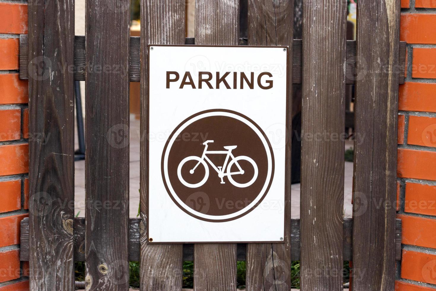 un' parcheggio posto per biciclette, un' cartello su un' di legno recinto foto