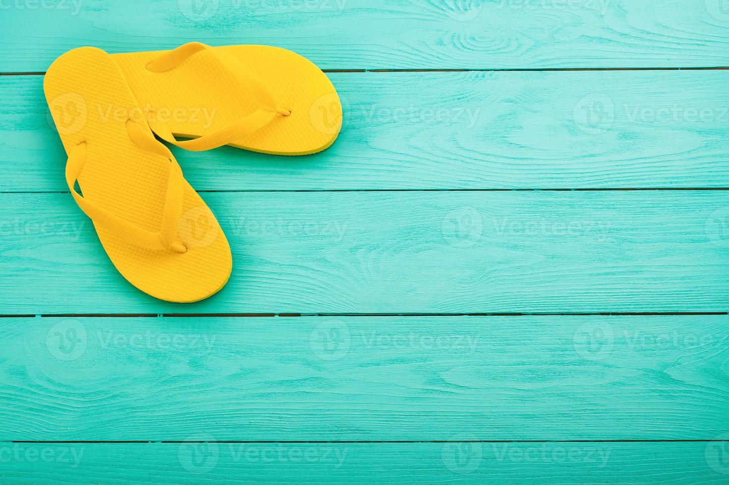 giallo Flip flop su blu di legno sfondo. estate vacanze. superiore Visualizza. finto su. copia spazio foto