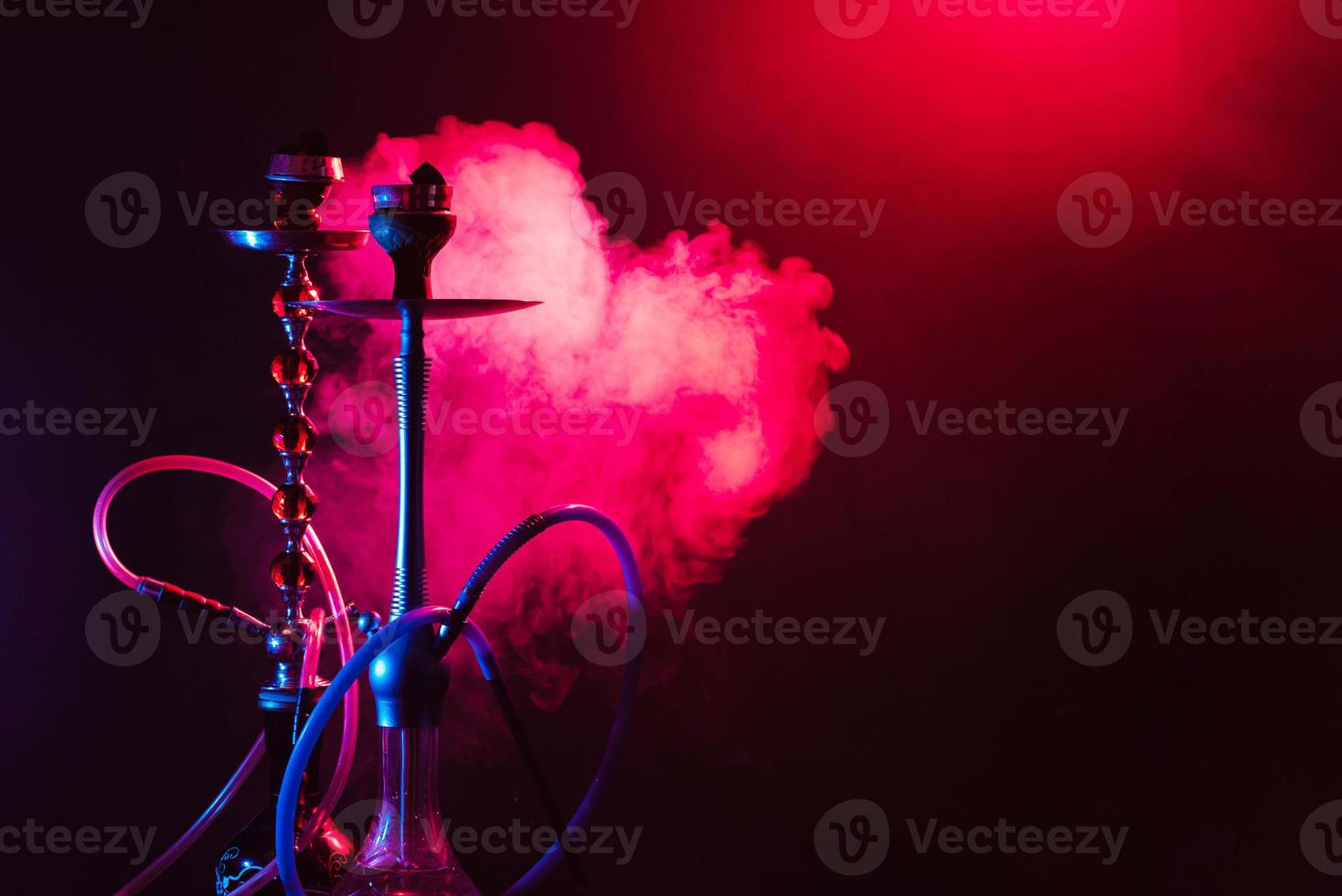 narghilè, shisha su un' fumoso nero sfondo con neon illuminazione e Fumo. posto per il tuo testo foto