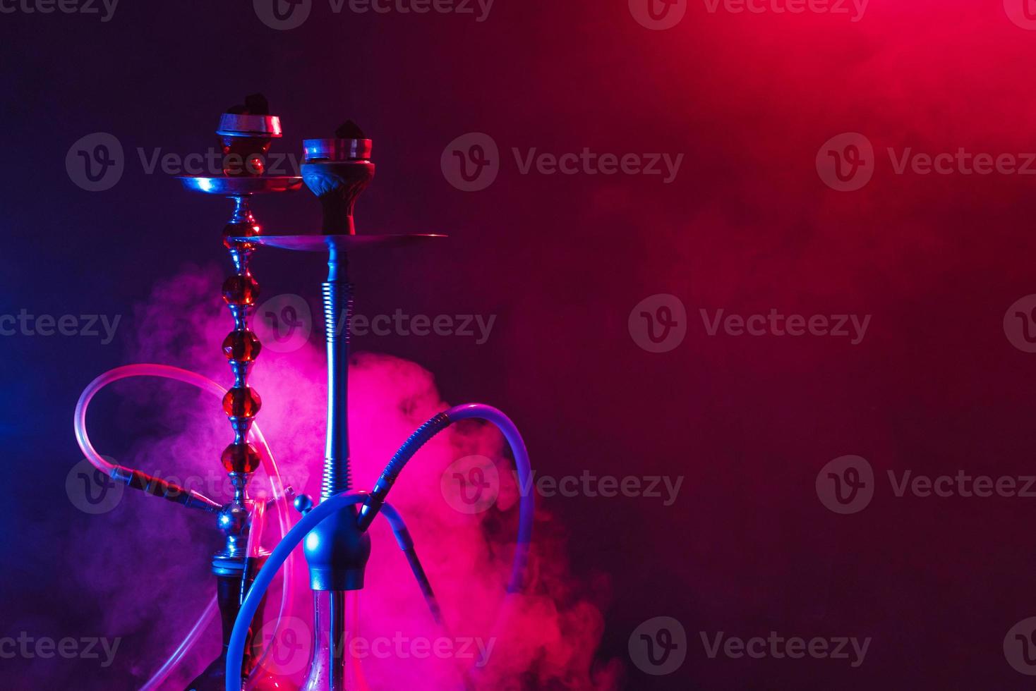 moderno narghilè, shisha su un' fumoso nero sfondo con neon illuminazione e Fumo. posto per il tuo testo foto
