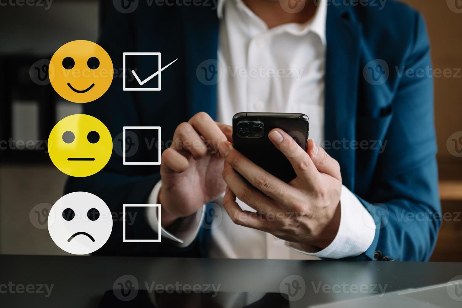 cliente servizio valutazione concetto. donna mostrare viso Sorridi emoticon mostrare su virtuale schermo a partire dal mano.guardando a inteligente Telefono, tavoletta e il computer portatile foto