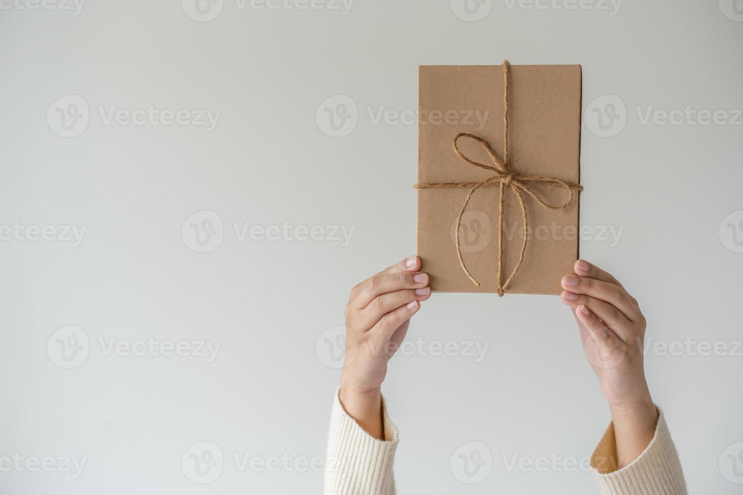 donna mani Tenere presente scatola con un' nastro arco. minimalista concetto di dando un' regalo. foto