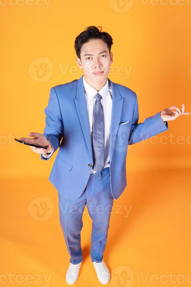 ritratto di giovane asiatico uomo d'affari utilizzando smartphone su sfondo foto